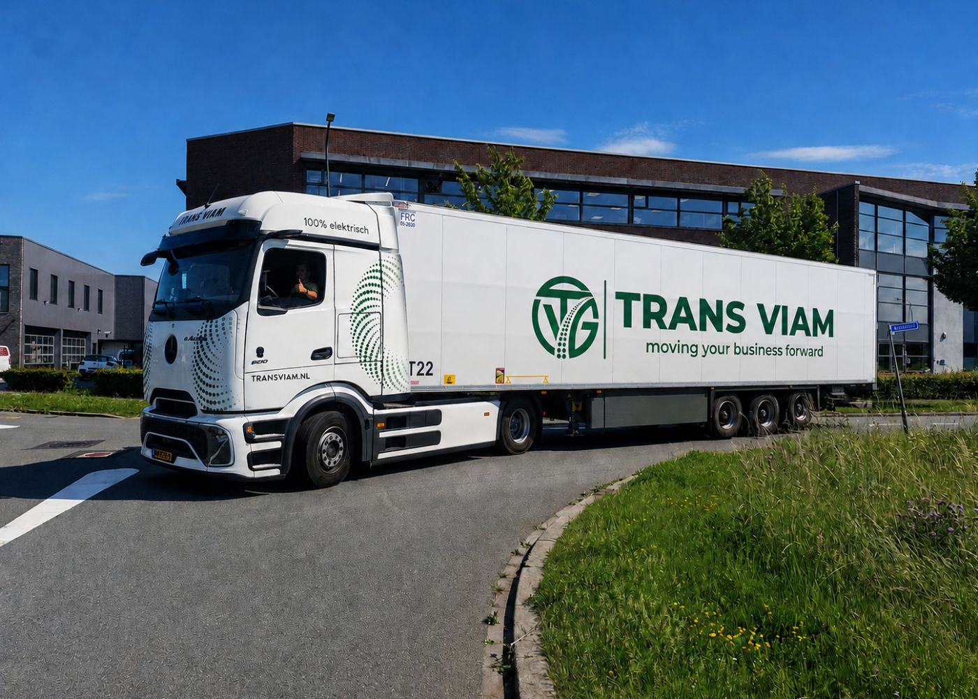 Chauffeur van Trans Viam steekt zijn duim op vanuit de cabine van een volledig elektrische trekker met oplegger