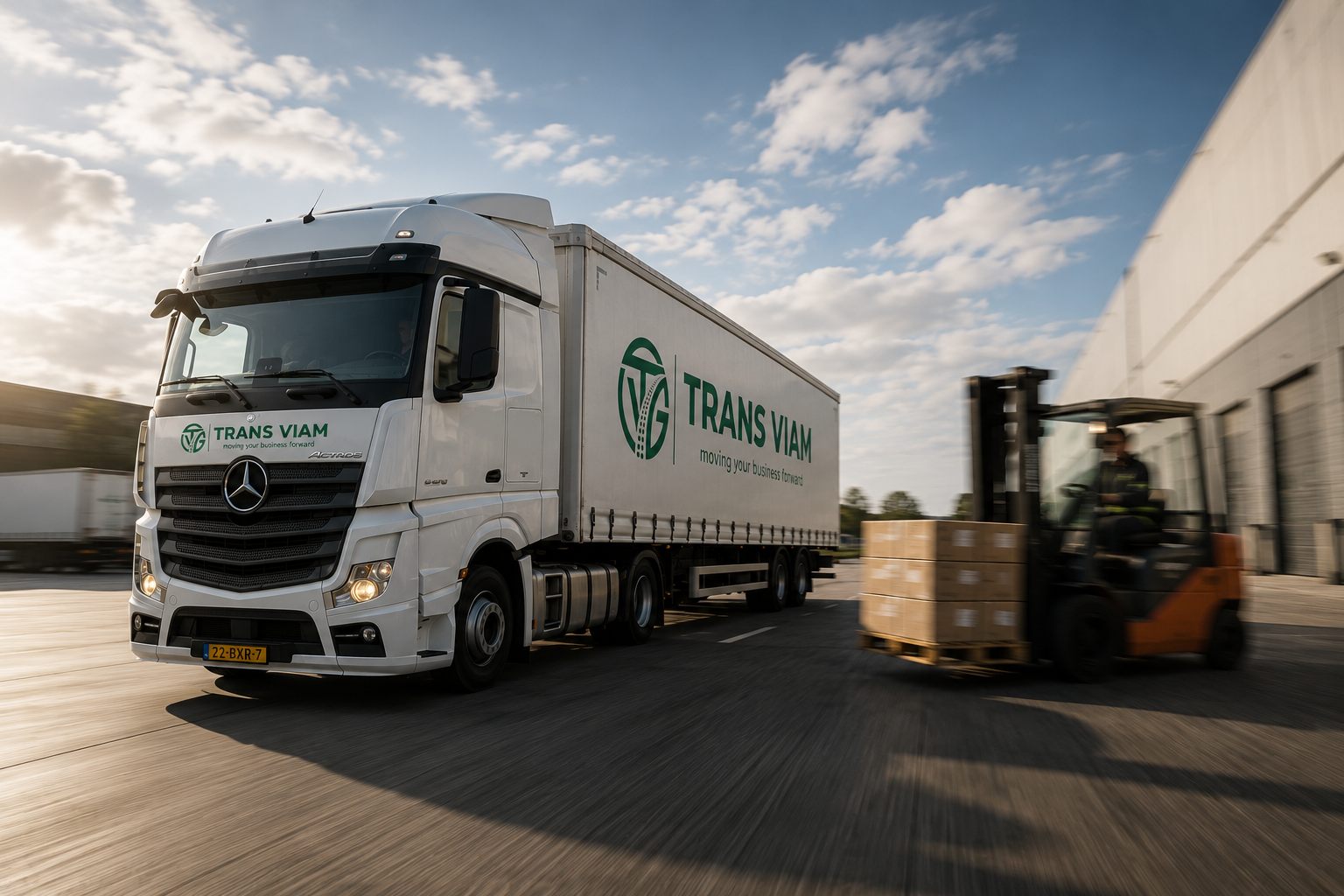 Trekker met oplegger vertrekt van het terrein terwijl een heftruck een pallet laadt